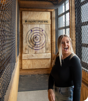 lady standing in front of the ax board